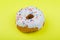 Donut with pink glaze on a yellow background