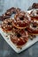 Donut rings with white and dark chocolate chippings and icing served on board