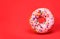 Donut with sprinkles over red