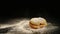 A donut with a sugar powder falls on a black desk