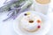 Donut with white icing on the plate of multi-colored jelly beans , the color purple, lavender, white coffee mug