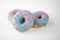 Donuts with blue glaze and pink sprinkles on white background. Top view.