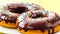 Donuts with chocolate glaze and sprinkles, on yellow background. Set of chocolate doughnuts Close-up