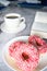 Donuts with coffee and milk. Donut with pink frosting