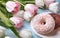 Donuts, coffee and tulips on a blue wooden background.