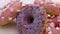 Donuts with different fillings on the white table rotation. Assortment of donuts of different flavors. Chocolate frosted