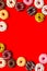 Donuts of different flavors for breakfast frame on red background top view space for text