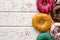 Donuts in different glazes on wooden background and space for text