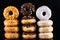 Donuts or Doughnuts Tower on Dark Background. Donut Stack Pile Food Background