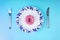 Donuts glaze on plate and cutlery on blue background