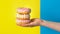 Donuts on the palm on a yellow-blue background