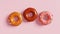 Donuts with pink, caramel and chocolate  icing on pink background. 3D render. Top view