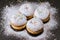 Donuts sprinkled with powdered sugar.