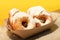 Donuts sprinkled with powdered sugar on a paper plate. Takeout food. Colored background