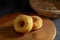 Donuts with sugar on a wooden plate over a dark table background