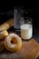 Donuts with sugar on a wooden plate over a dark table background