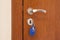 Door handle with inserted key in the keyhole with blue keyholder