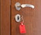 Door handle with inserted key in the keyhole with red keyholder