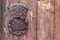 Door knocker on the old wooden gate of the chapel close-up. Door handle hanging on an old gate