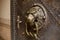 A door knocker in the shape of a lion adorns an old door