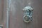 Door knocker on wooden ancient home gate background with portrait man face