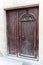 The door is made of old wood with interesting door decorations in Catalonia, Spain.
