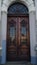 door. Old wooden entrance doors with a brass handle in the city. Arched door. A beautiful street door with an arch