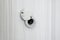 Door peephole from the chromeplated steel in an entrance door from white wood