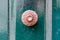 Doorhandle of ancient green painted wooden door made out of meta