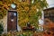 Doors and facade braided with ivy, Autumn leaves on the ground, table with bottles and vases, courtyard of the house. Medieval