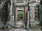 Doorway through the ancient temples of Angkor, statues on the side of the door