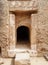 Doorway carved into rock with carving and pillars at the tomb of the kings in cyprus