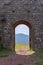 Doorway of Radicofani fortress with the distant sunny perspective of a mountain, Tuscany, Italy