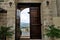 Doorway in stone wall. One half of the wooden door is open.