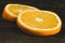 Dorange slices on an orange wooden background. Top view