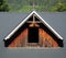 Dormer window with wooden panel on painted grey metal roof