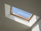 dormer wooden window in the white sloping ceiling overlooking the blue sky