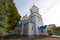 Dormition of the Mother of God Orthodox church and churchyard, old woman believer exit the building