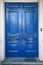 Double antique front doors painted in a glossy cobalt blue paint