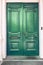 Double antique front doors painted in a glossy grass green paint
