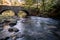 Double Arch stone bridge over gently flowing Flatbrook River in Stokes State Forest, NJ, in fall