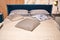 Double bed with blue velor headboard, soft pillows and woolen throw on top