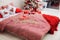 Double bed in a Christmas interior near white brick wall. Christmas Holiday - themed bedding, linens and pillows. Checkered beddin