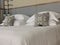 Double bed with white linens and two gray throw pillows.