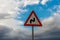 Double bend road sign against clearing sky