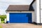 Double car garage with blue metal door. England. UK