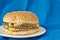 Double cheeseburger on blue linen background