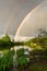 Double colorful rainbow over grey sky