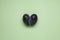 Double conjoined plum in form heart on a green background. Ugly prune.  Flat lay, top view, copy space. Concept - Food waste