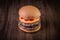 Double craft beef burger with cheddar cheese, caramelized onion.and pepper pout on wood table and rustic background